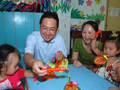 Mr Chen presents lanterns to children at a temporary campus of Chongzhou Zhengdong Jie Kindergarten for celebrating the coming Mid-Autumn Festival.